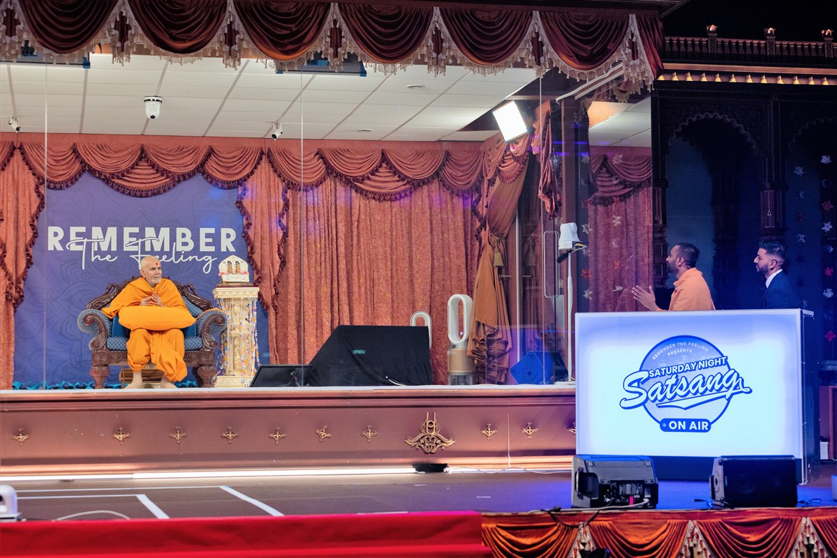 Paramsetudas Swami explains to Swamishri the challenging scenario facing the kishore character in the drama