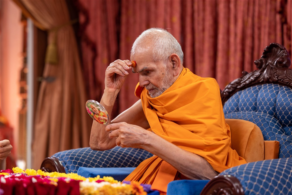 Swamishri applies a chandlo to his forehead