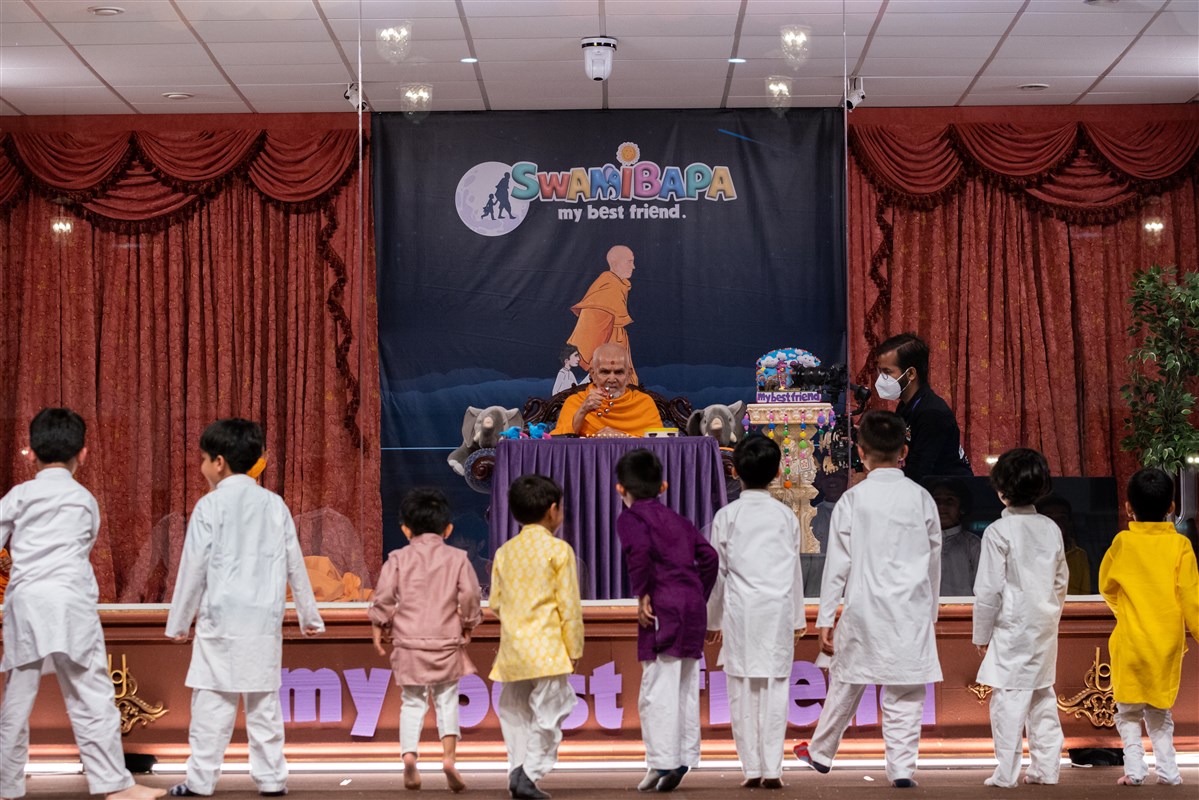 Children dance as Swamishri plays some musical bells