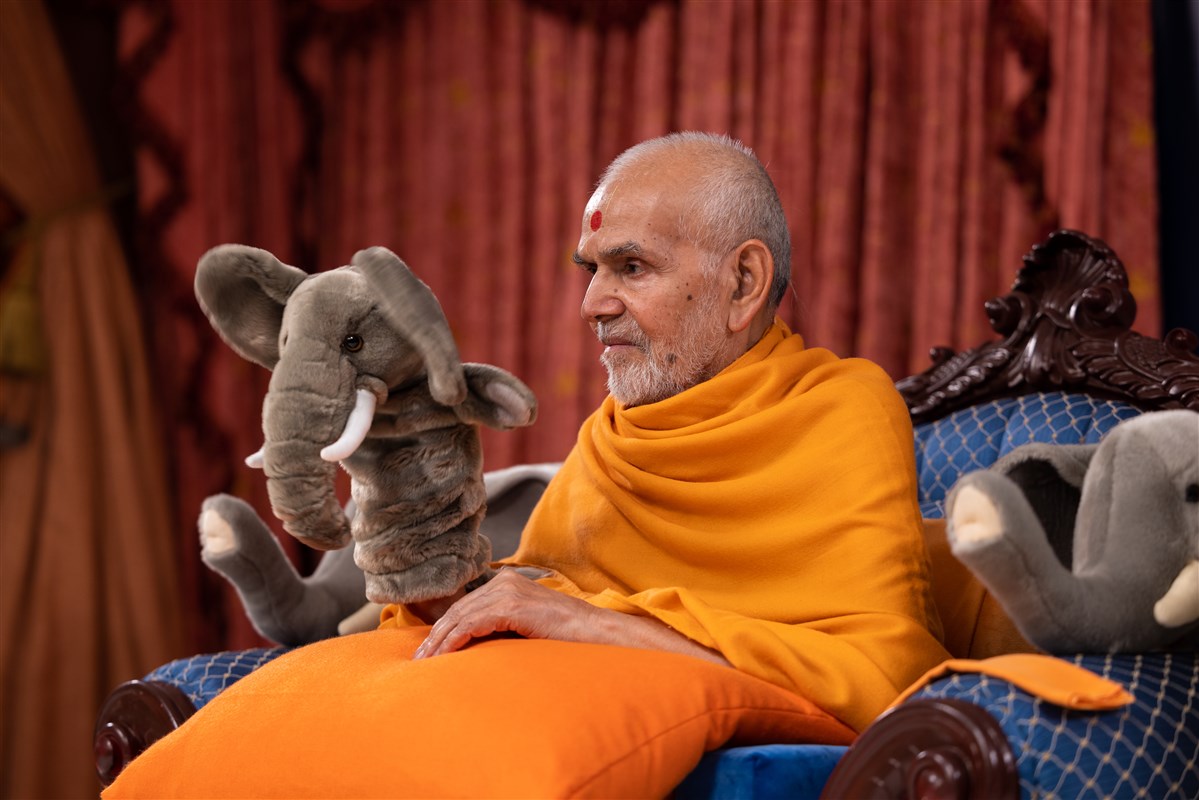 Swamishri interacts with the children using a hand puppet