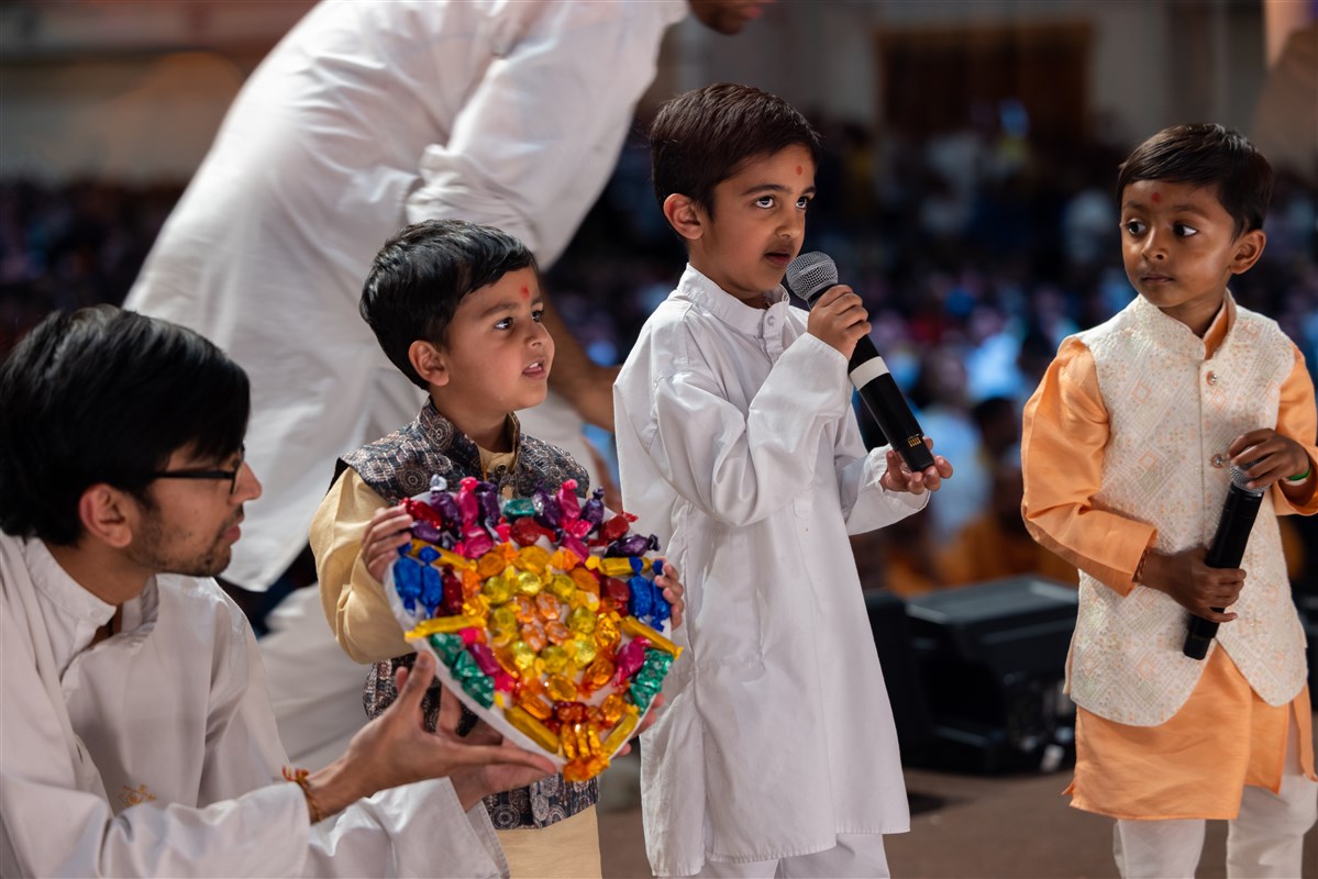 Children present their hand-crafted devotional offerings, such as a heart-shaped chocolate arrangement
