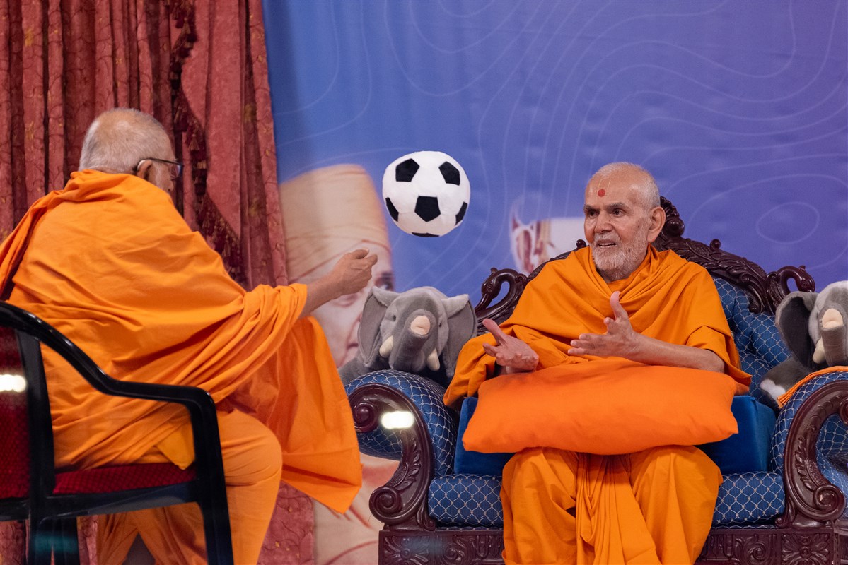 The children request Swamishri to play catch with a football with Bhaktipriyadas Swami