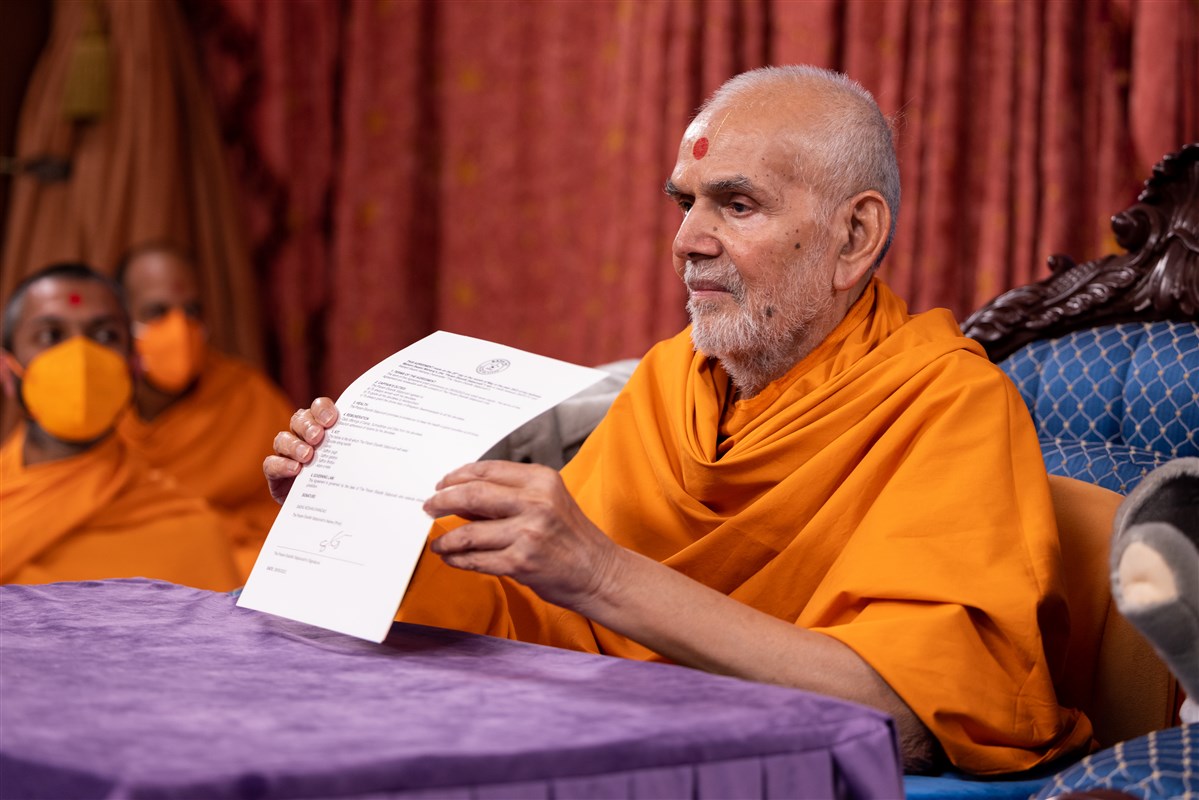 Swamishri presents the signed contract to the assembly