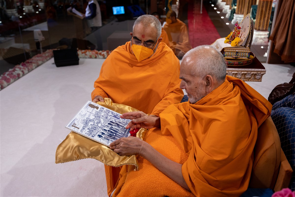 Mahant Swami Maharaj appreciated the artistry and vision when observing an enlarged copy of the Coronation stamp