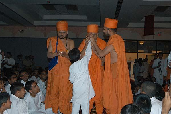 A balak applies a chandlo to Swamishri's forehead 