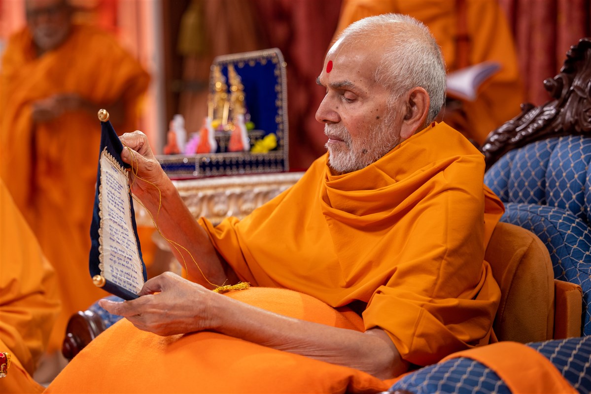 Swamishri unfurls the scroll and reads the prayer