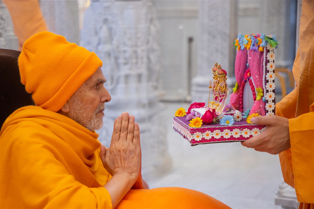 Param Pujya Mahant Swami Maharaj engrossed in the darshan of Shri Harikrishna Maharaj and Shri Gunatitanand Swami Maharaj