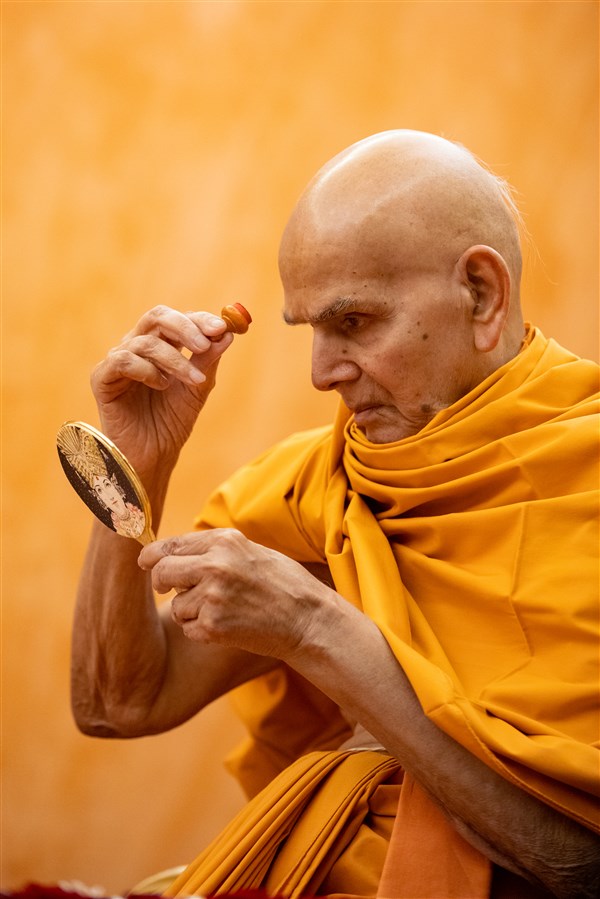 Swamishri applying a chandlo to his forehead