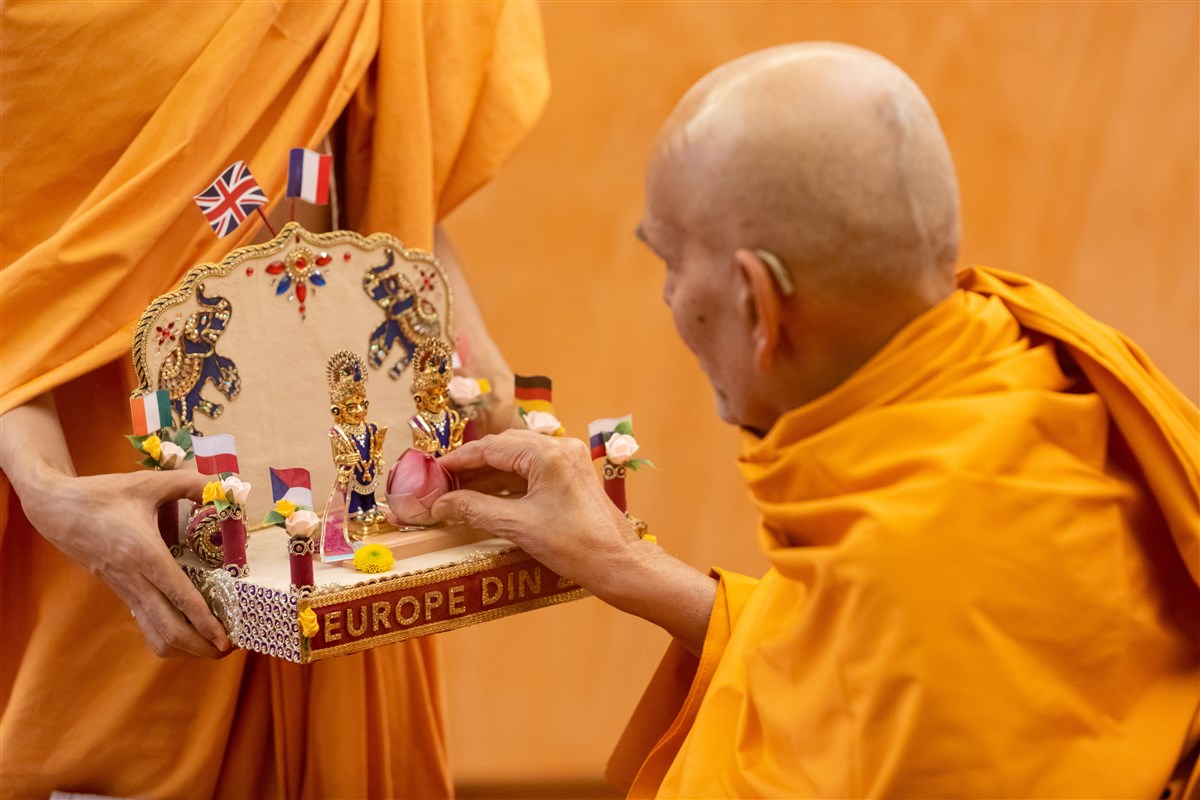 Swamishri offers a lotus to Shri Harikrishna Maharaj and Shri Gunatitanand Swami Maharaj