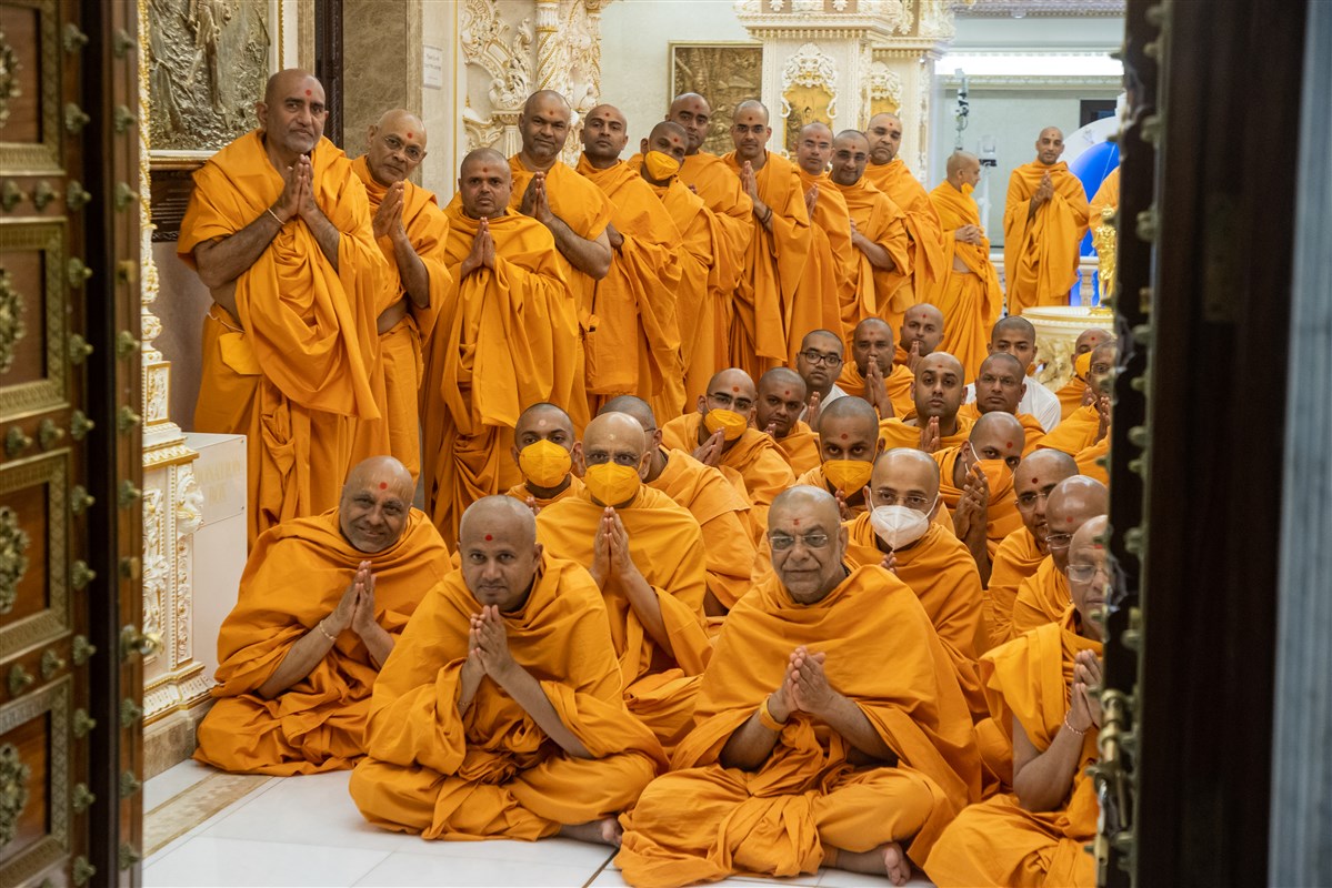 Swamis engrossed in Swamishri's darshan with folded hands