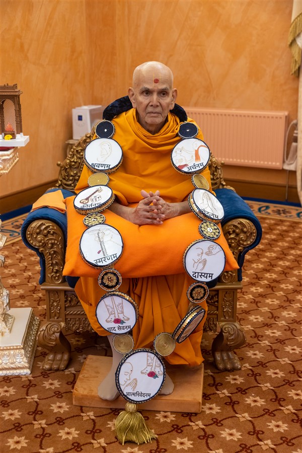Swamishri adorning a devotional garland