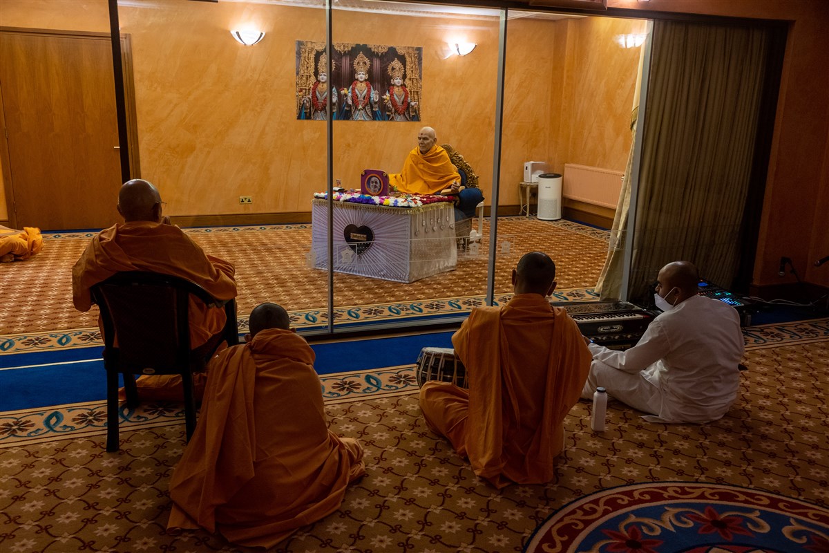 Swamis and sadhaks offer kirtan bhakti in Swamishri's puja