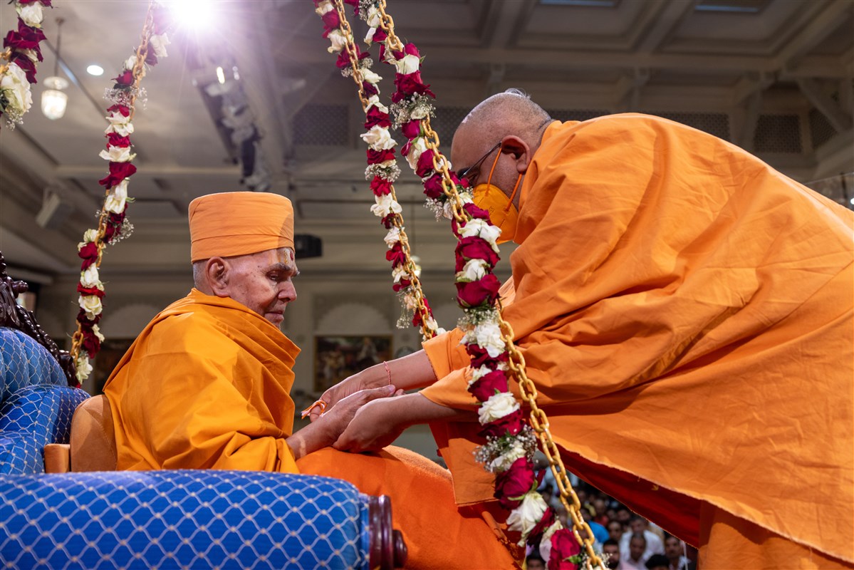 Yogvivekdas Swami ties a nadachhadi on Swamishri's wrist