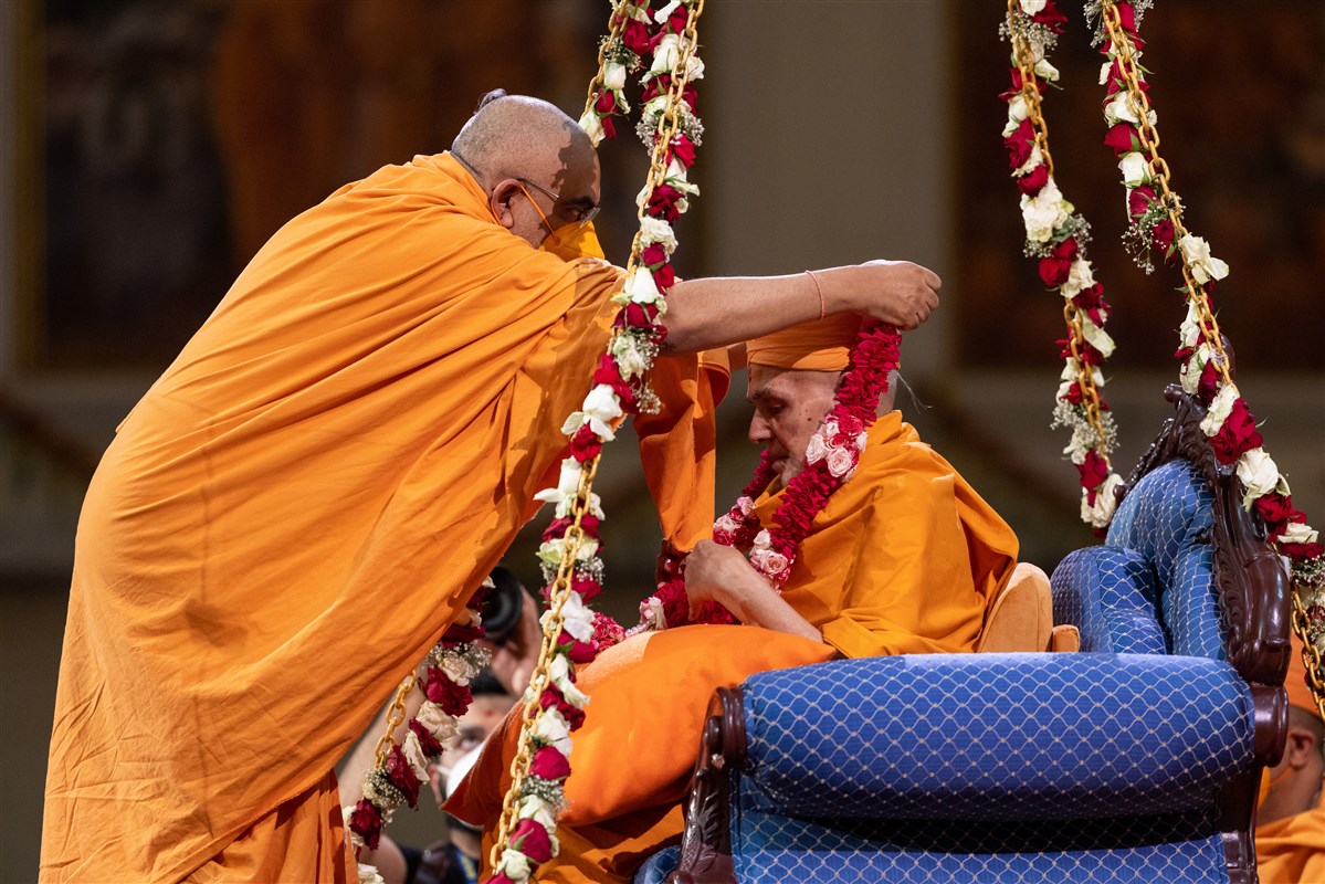 Yogvivekdas Swami honours Swamishri with a garland