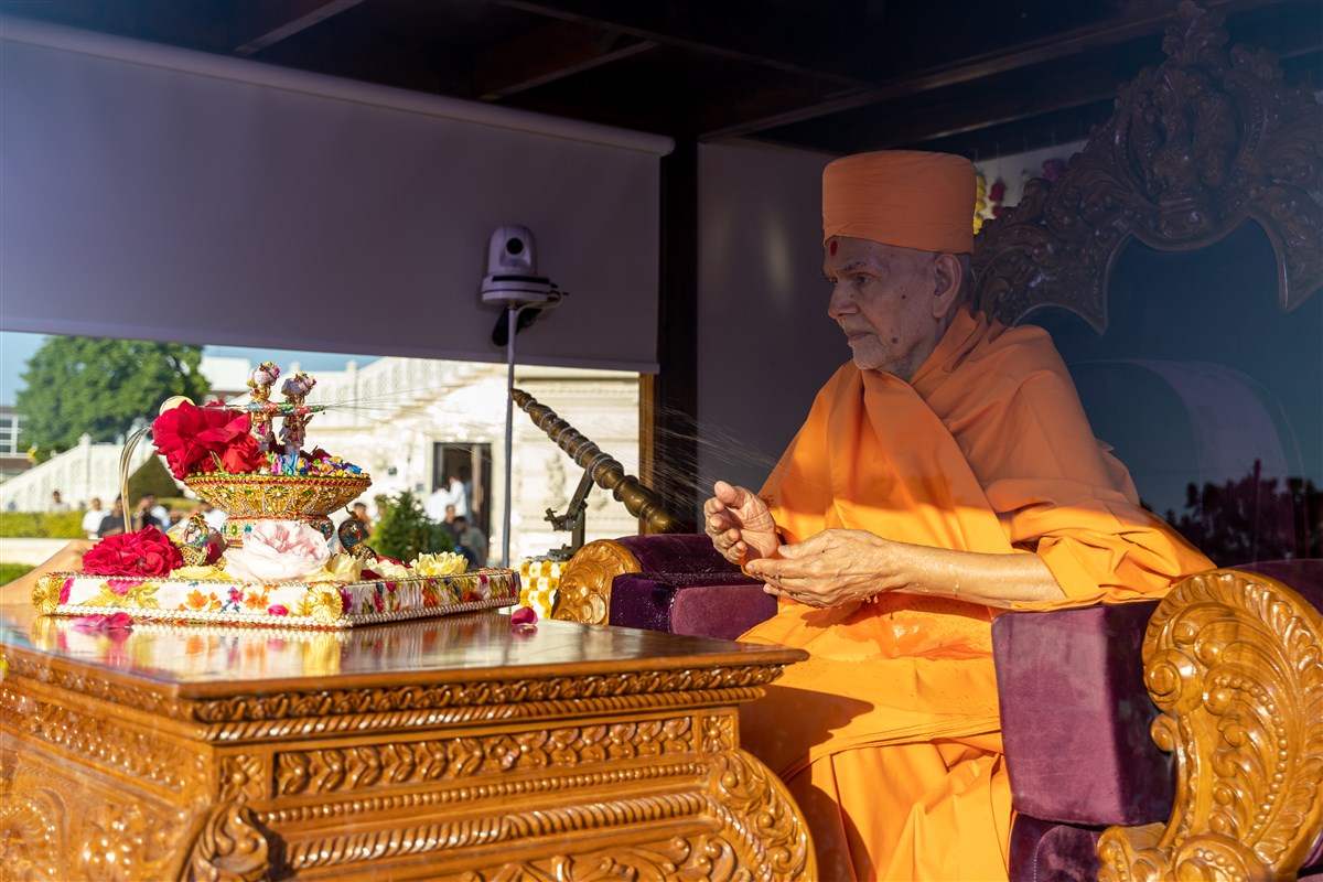 Shri Harikrishna Maharaj and Shri Gunatitanand Swami Maharaj commence the rangotsav by spraying Swamishri with coloured water