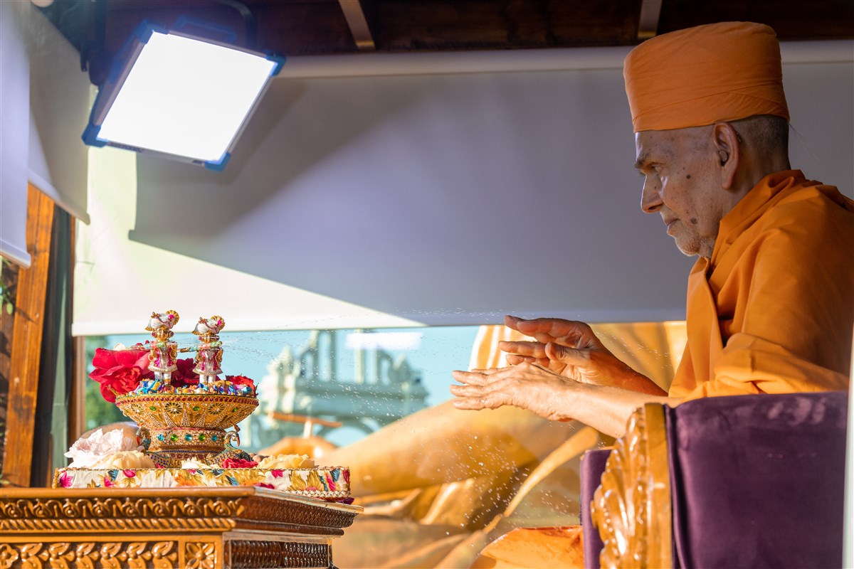 Shri Harikrishna Maharaj and Shri Gunatitanand Swami Maharaj spray Swamishri with coloured water