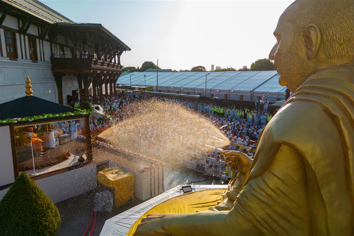 ...and Pramukh Swami Maharaj spraying Swamishri with coloured water