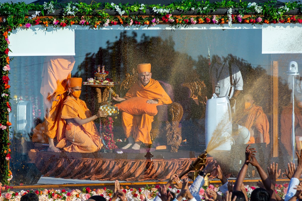 Swamishri spraying devotees with coloured water