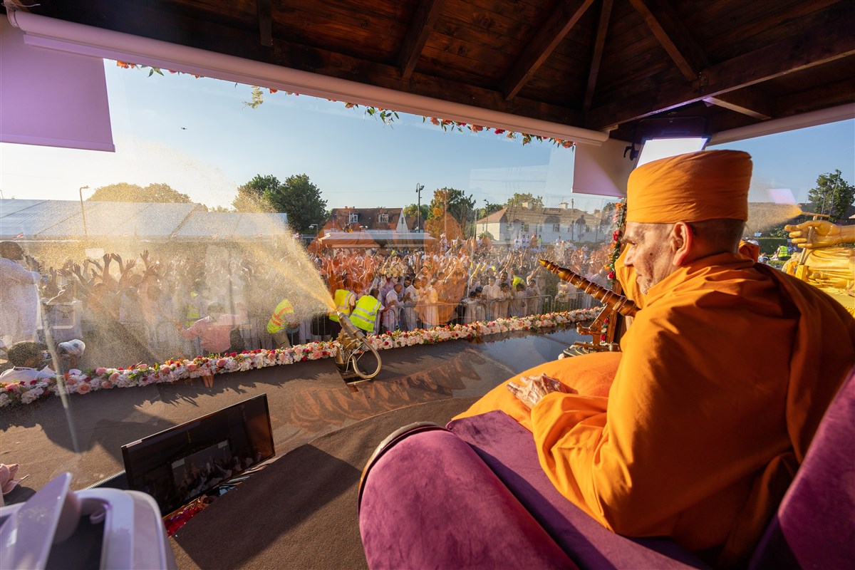 Swamishri spraying devotees with coloured water