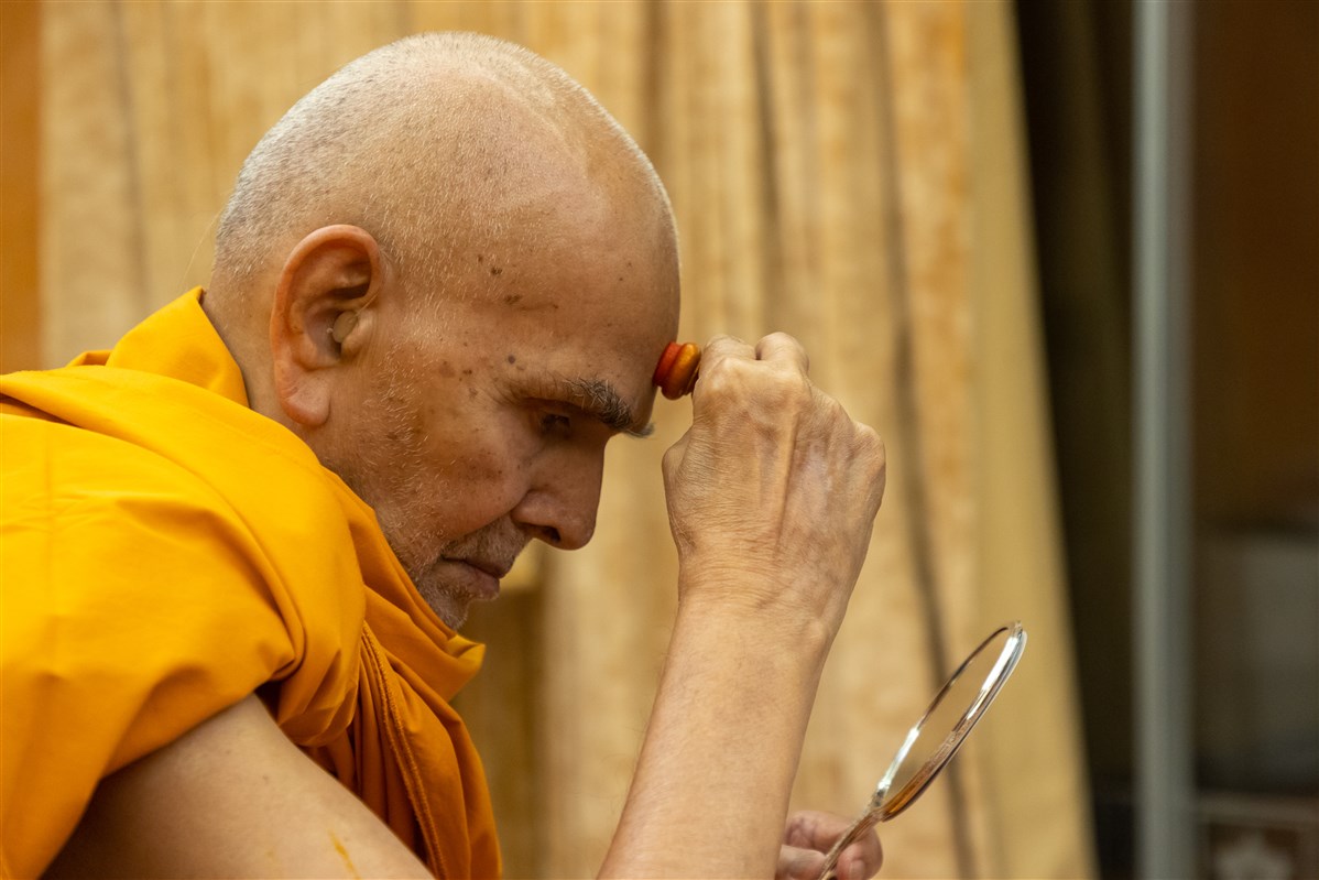 Swamishri applies a chandlo to his forehead