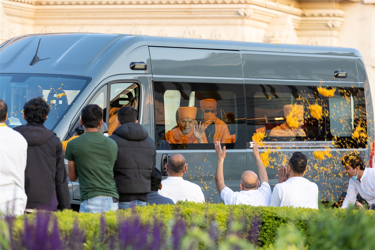 Swamishri greets devotees as they bid goodbye with a shower of flower petals