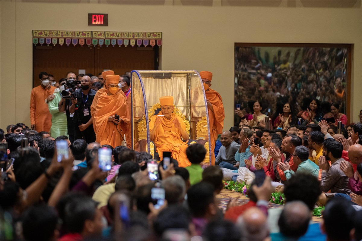 Swamishri's entry into the assembly hall is met with a hearty applause
