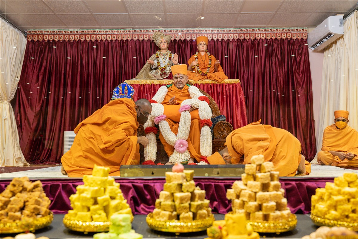 Swamis present Swamishri with a garland of puffed rice, lovingly crafted by the women devotees