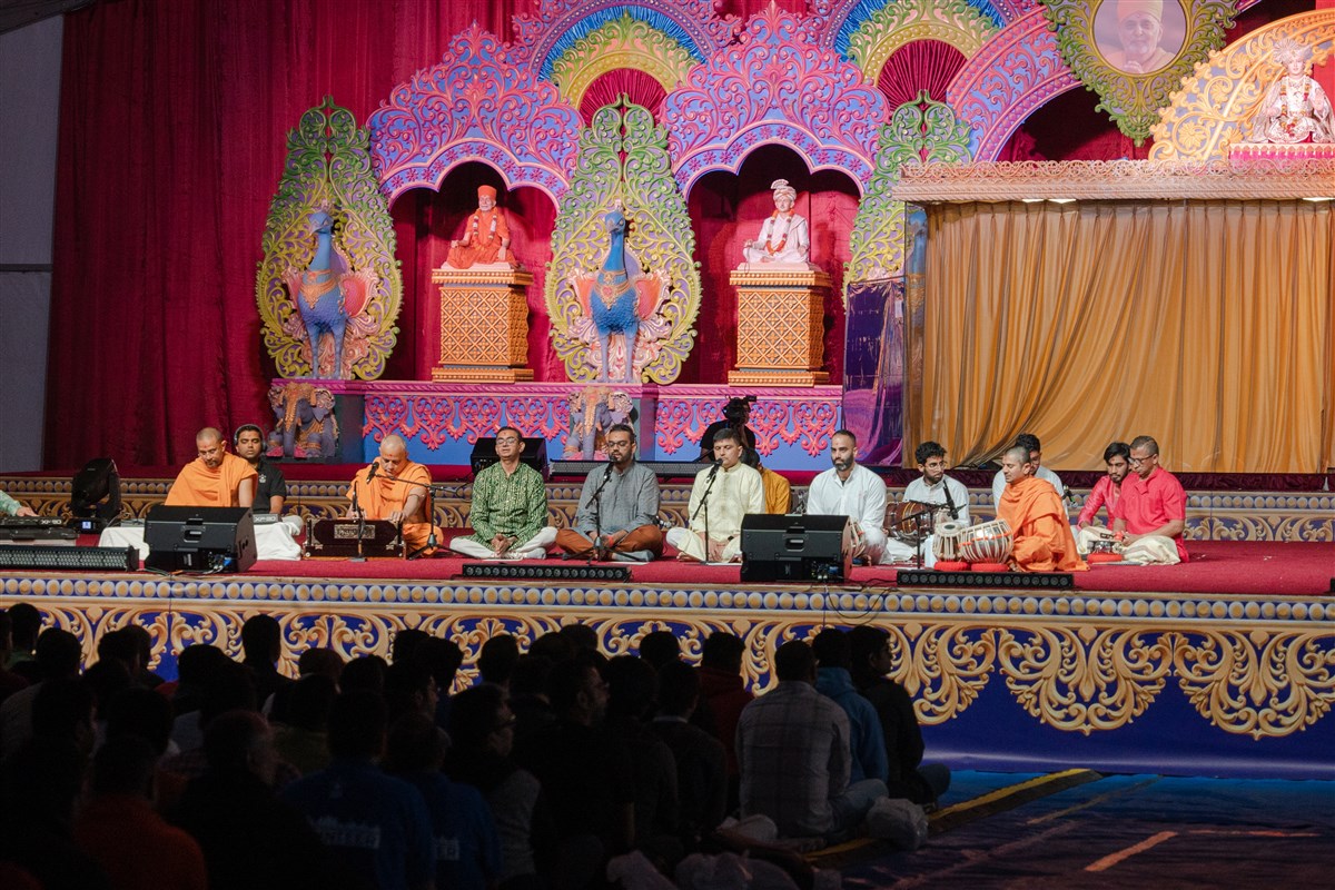 Devotees sing kirtans during the evening Swagat Din assembly