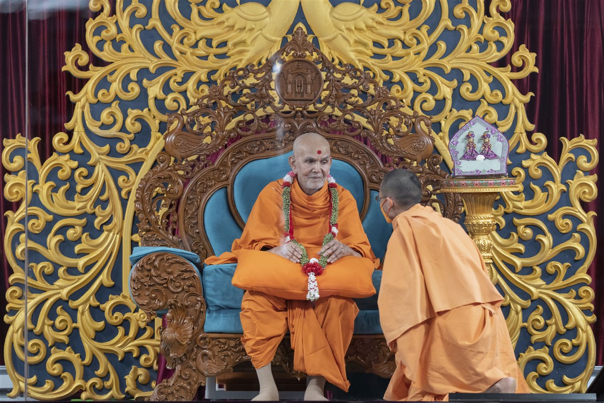 Swamishri presented with a garland made of cardamom