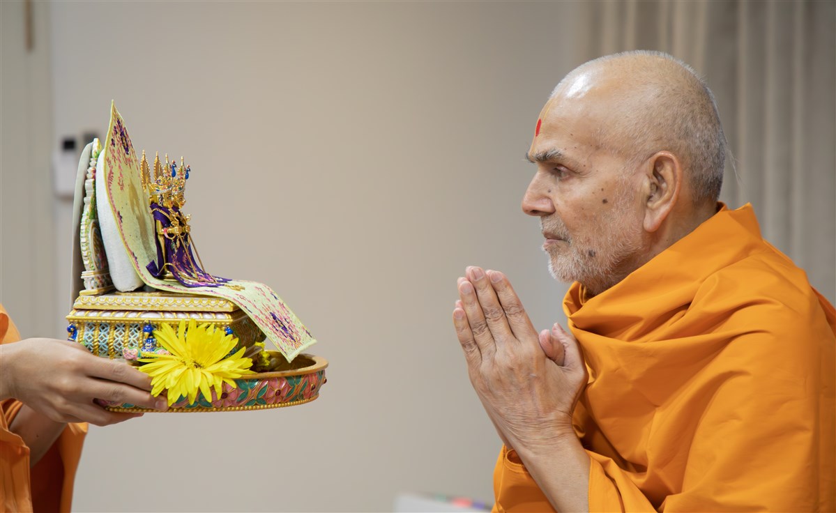 Swamishri engrossed in the darshan of Shri Harikrishna Maharaj and Shri Gunatitanand Swami Maharaj
