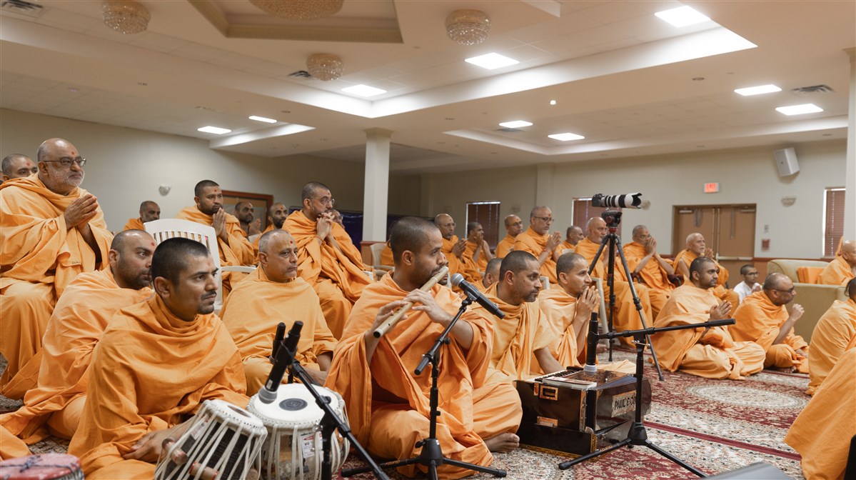 The melodious sound of the flute fills the air as Swamis engage in darshan of Swamishri
