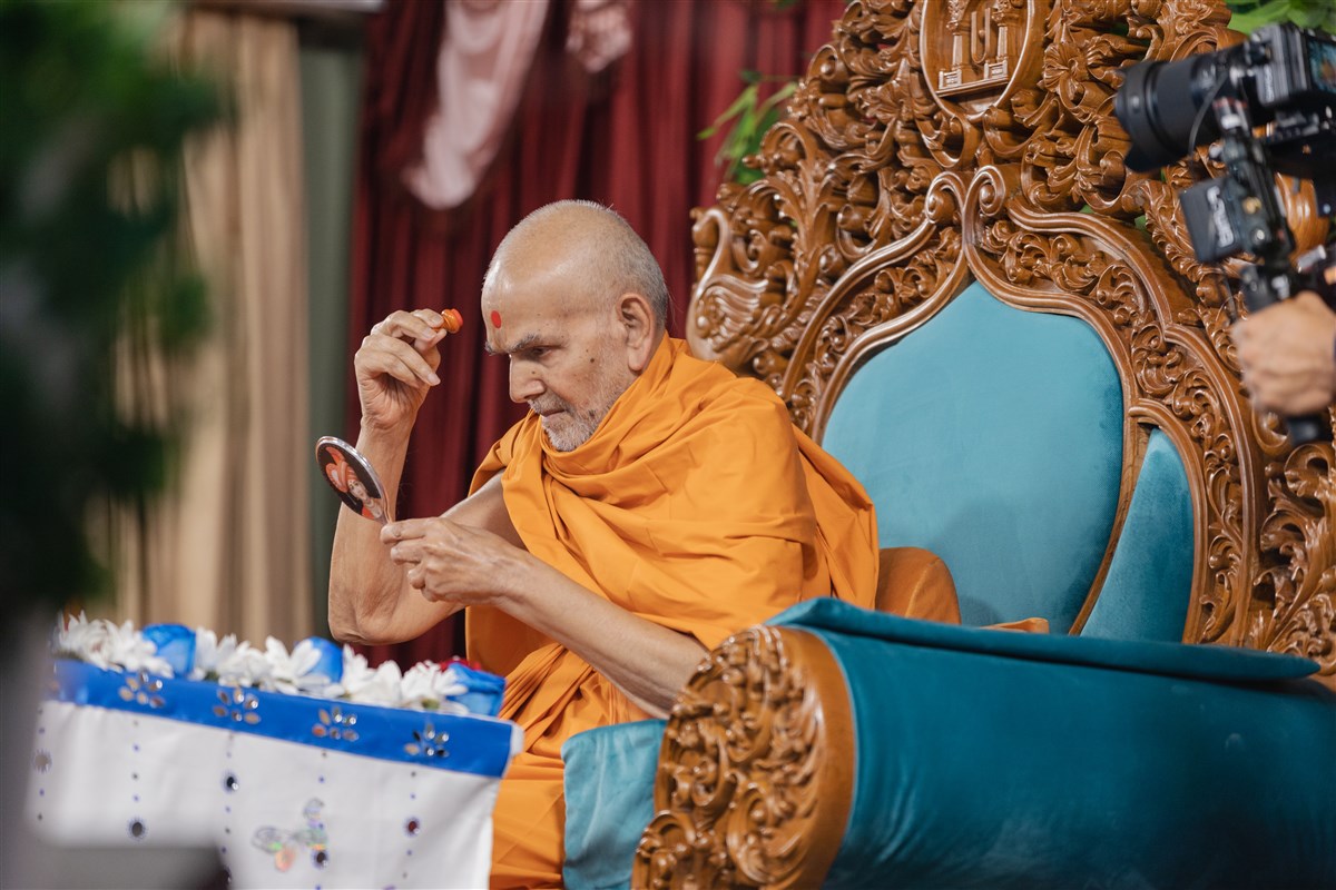 Swamishri applies a chandlo on his forehead