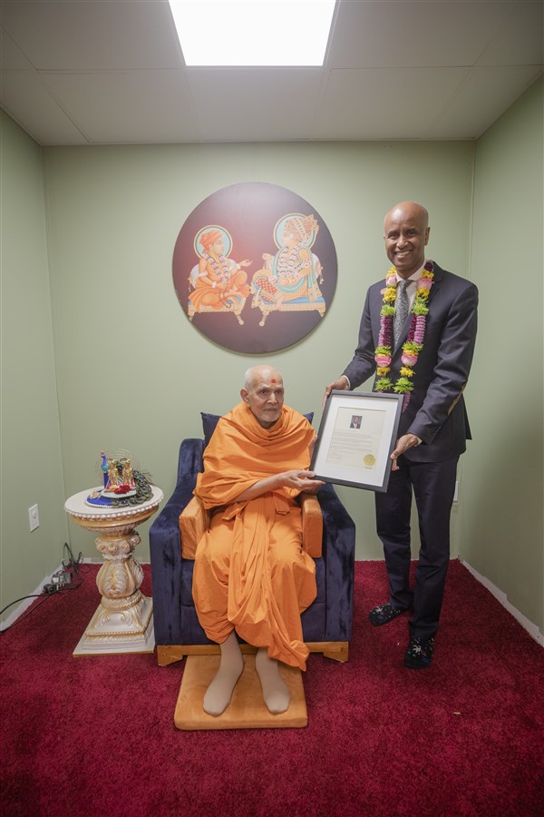 Hon. Ahmed Hussen, Minister of Housing and Diversity and Inclusion presents a proclamation to  HH Mahant Swami Maharaj