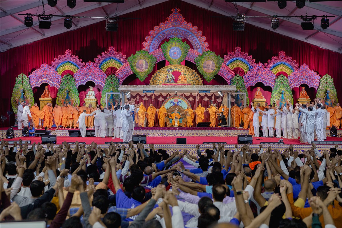 Swamishri, swamis and devotees joins hands in a gesture of unity