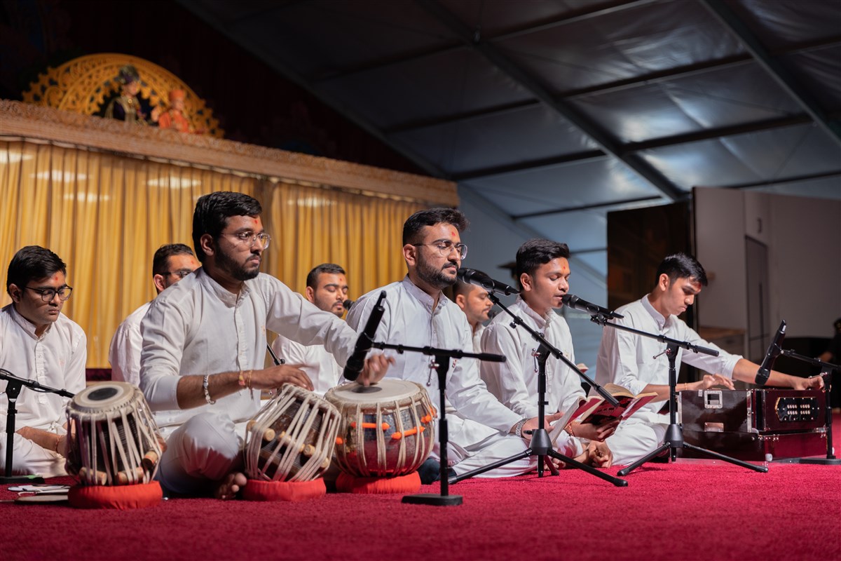 Youths offer kirtan bhakti in the evening assembly