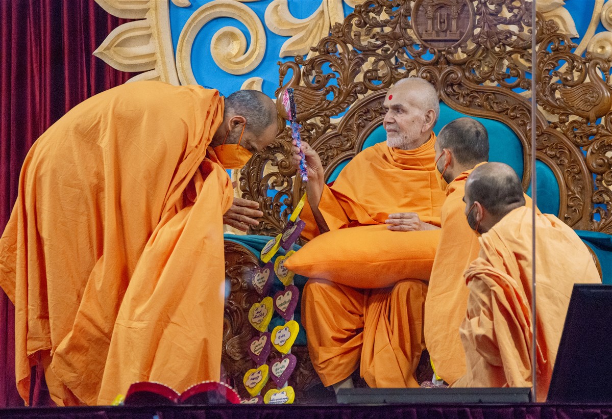 After being garlanded by a Swami, Swamishri graciously blesses him