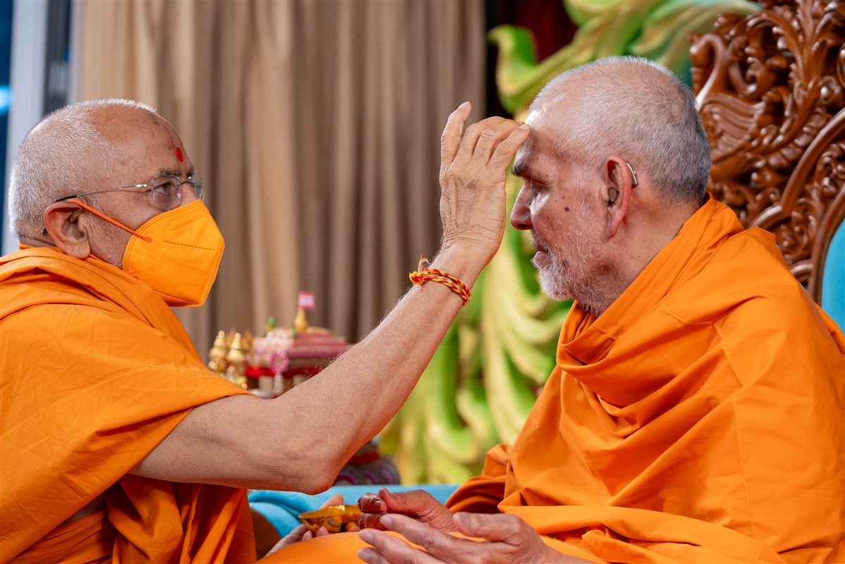 Gnanpriyadas Swami applies chandan archa to Swamishri