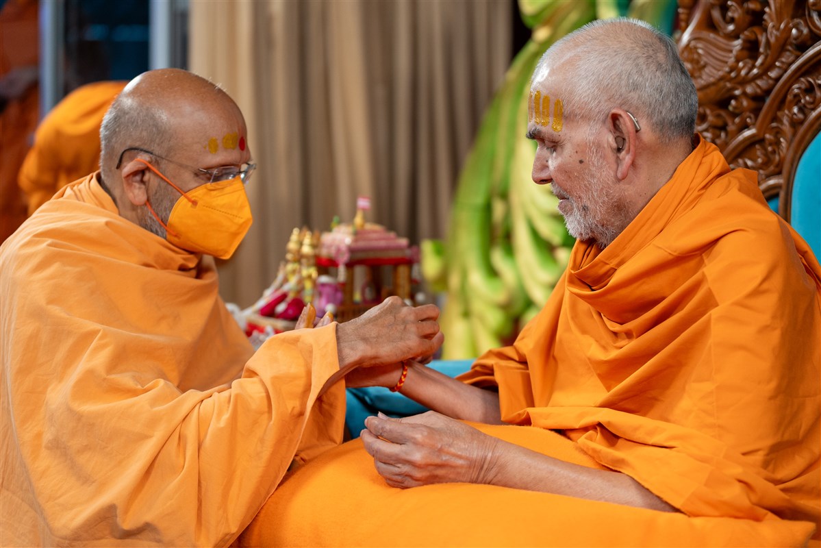 Yagnavallabhdas Swami ties a nadachadi on Swamishri's wrist