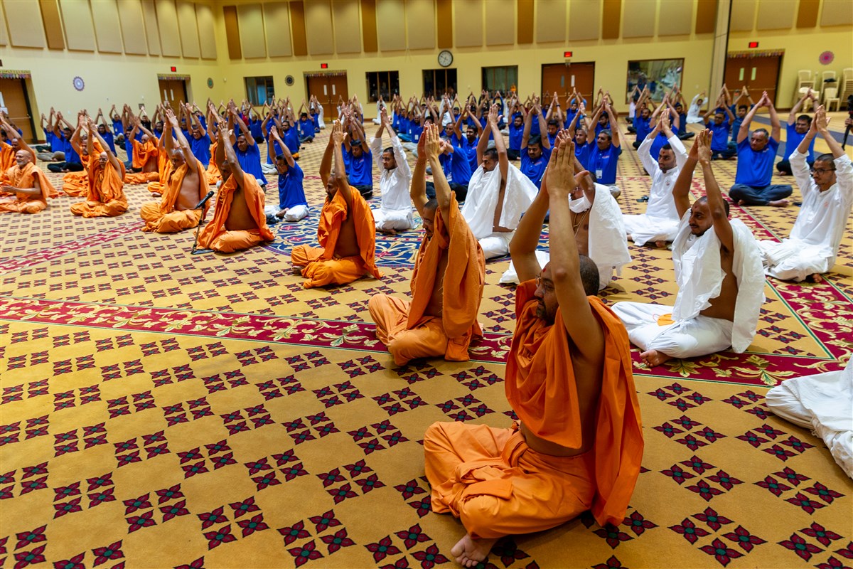 Swamis and devotees practice yoga in observance of the International Day of Yoga