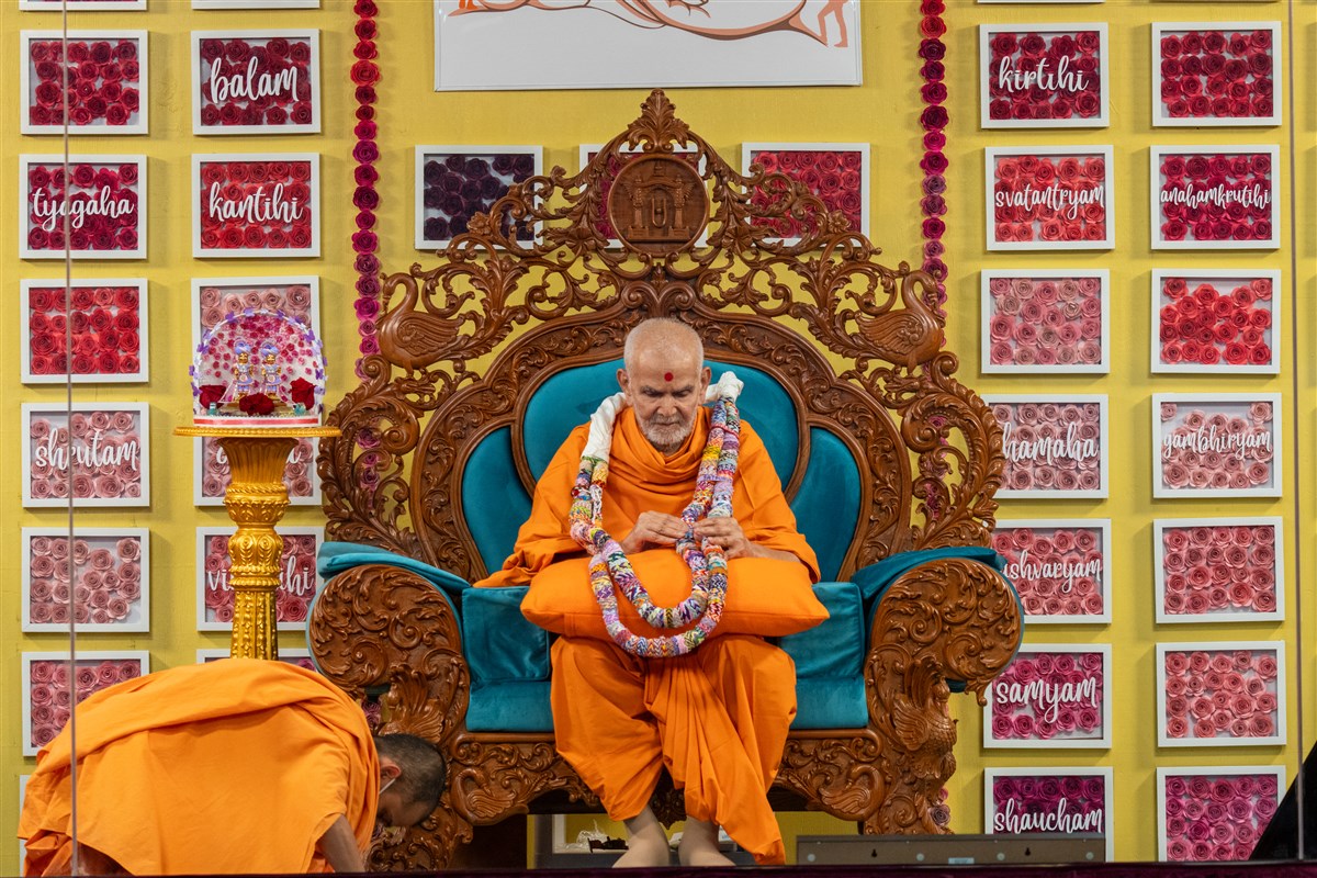 Swamishri observes the garland presented to him