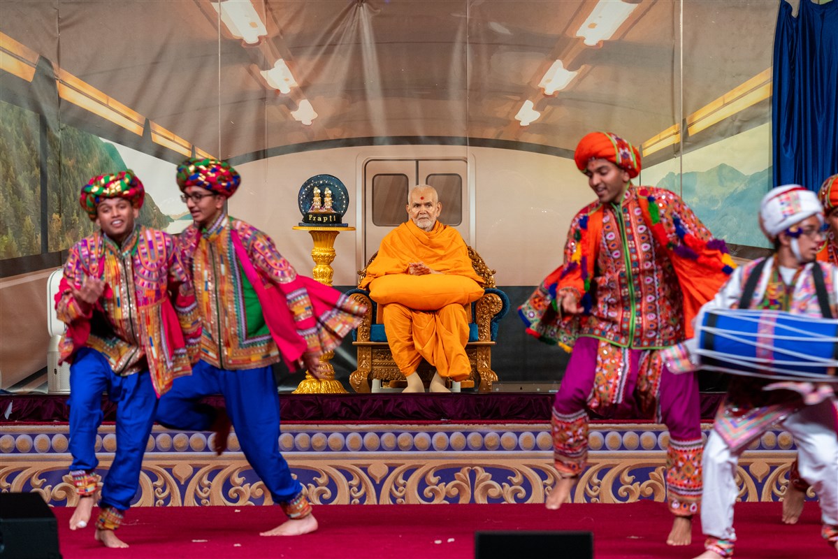 Swamishri watches attentively as youths perform a cultural dance
