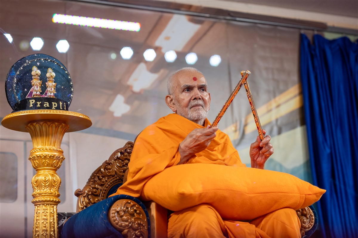 Swamishri playing with the raas sticks