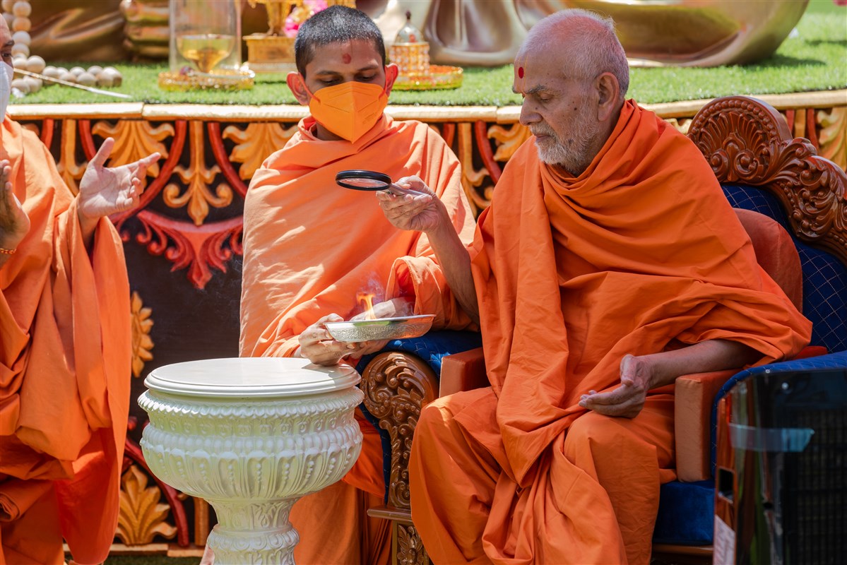 Swamishri ignites a flame with sunrays for the Festival of Inspirations Yagna ceremony