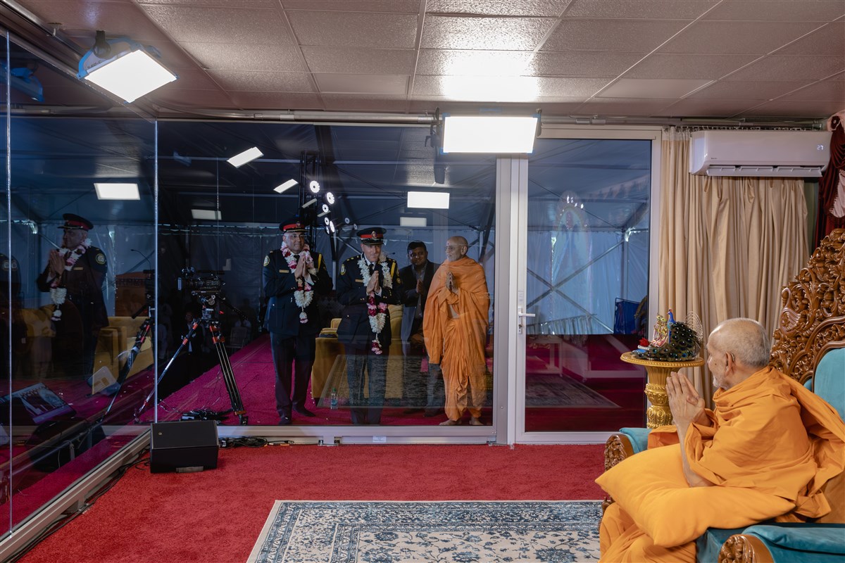 Swamishri greets Superintendent Mandeep Mann (Toronto Police Service) and Inspector Jack Gurr (Toronto Police Service) with folded hands