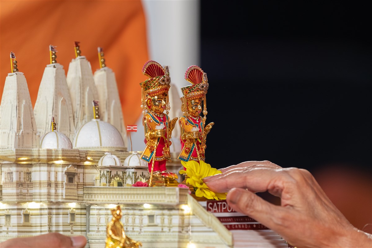 Swamishri offers flowers to the murti of Shri Harikrishna Maharaj and Shri Gunatitanand Swami Maharaj