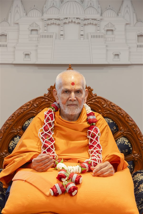 Swamishri adorning a garland
