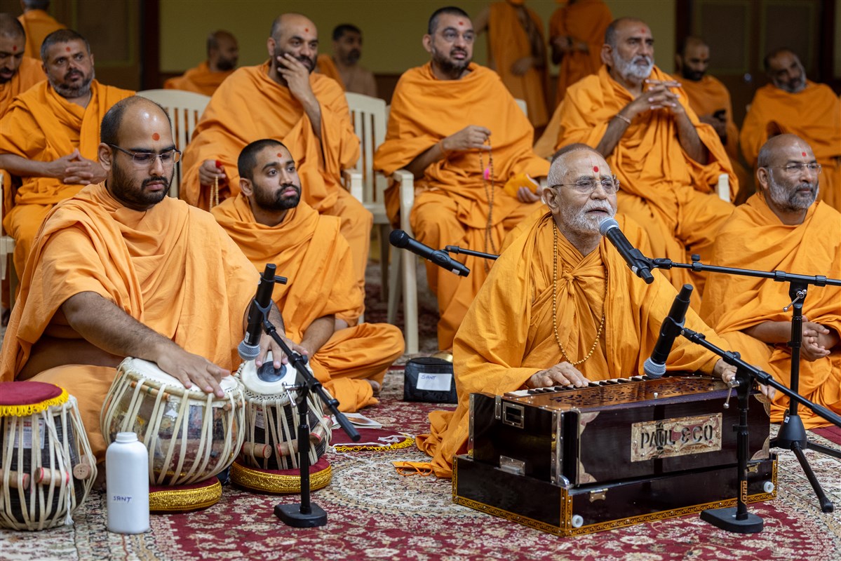 Swamis offer kirtan bhakti during Swamishri's puja