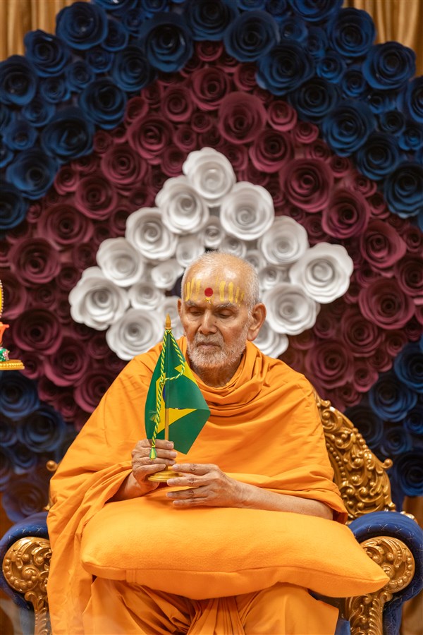 Swamishri holds the Brazilian flag to mark the formal establishment of the Satsang Mandal in Brazil