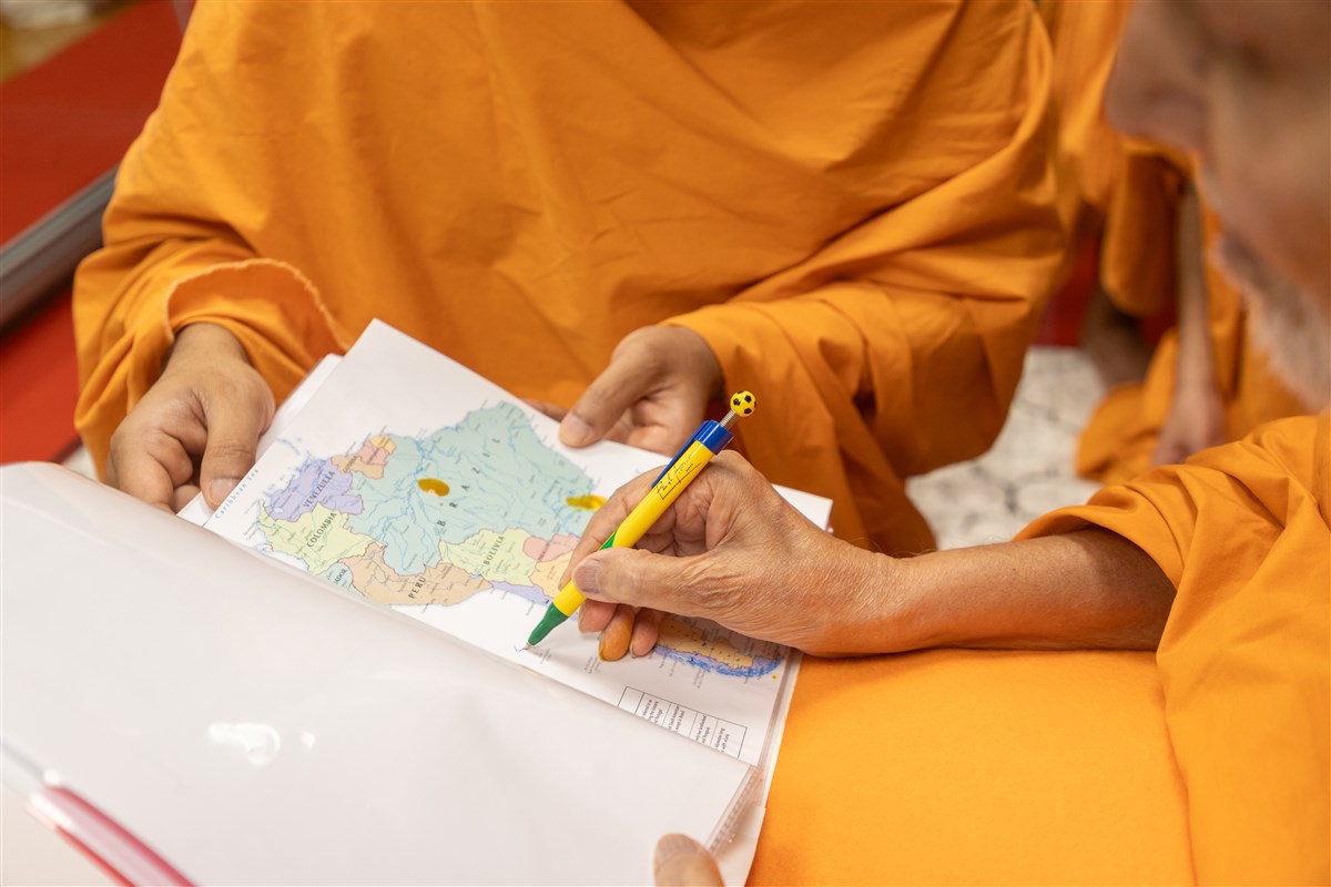 Swamishri signs the map of South America and mentions 'South America Rangvu Chhe'