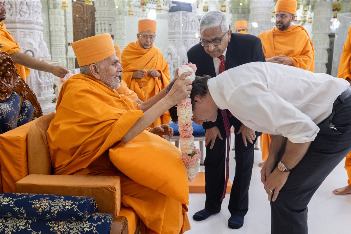 HH Mahant Swami Maharaj welcomes Prime Minister Trudeau with a garland